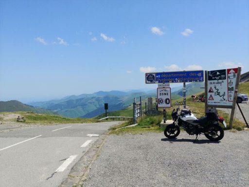 Motorrad an einer Bergstraße mit weitem Blick über die grünen Landschaften der Pyrenäen