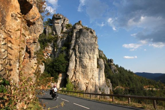Hohe zerklüftete Felsformationen direkt neben einer kurvenreichen Straße in Südfrankreich
