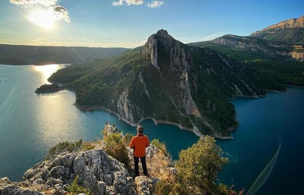 Aussichtspunkt über einem türkisblauen Stausee mit steilen Felswänden und bewaldeten Bergen